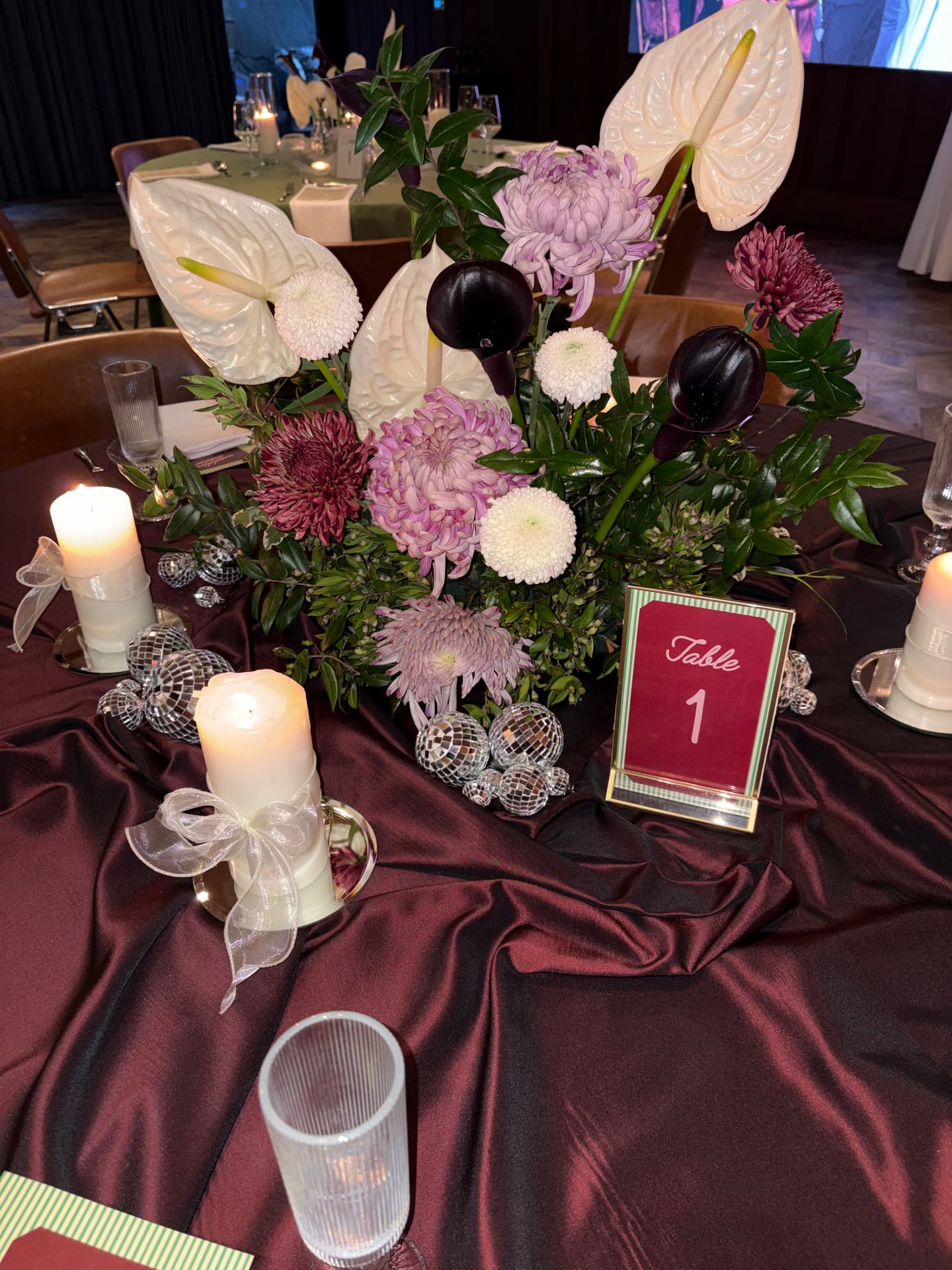 Table 1 centrepiece with anthuriums, chrysanthemums, candles and mirror balls